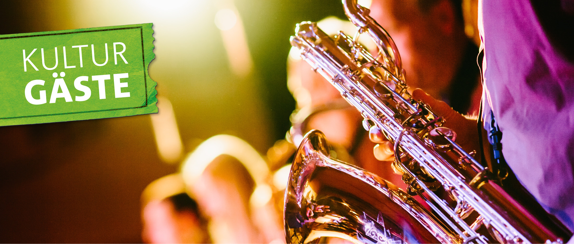 Ein Saxophon in der Hand eines Musikers im Scheinwerferlicht