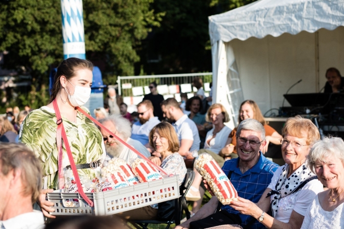 A young woman sells popcorn to the crowd