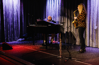 Ein Mann spielt Klavier und eine Frau spielt Saxophon